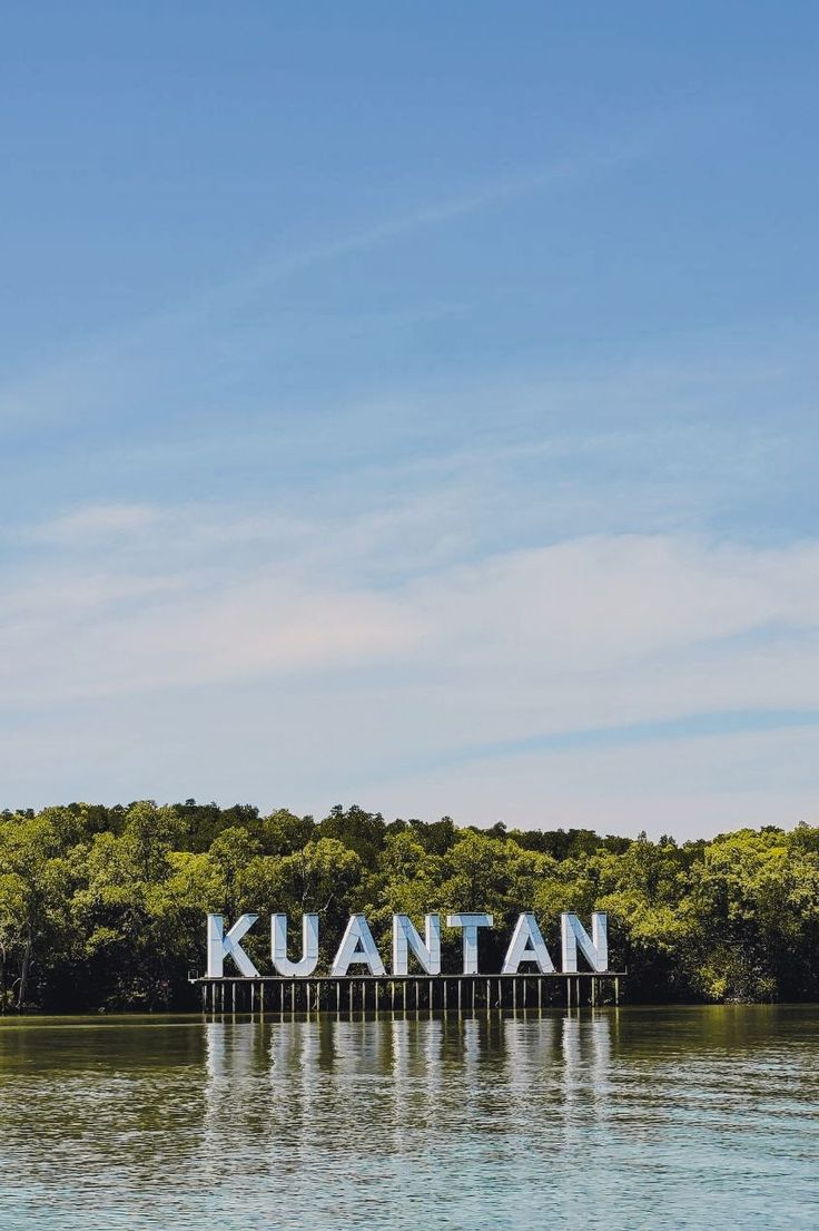 a large sign that reads kuantan on the side of a body of water