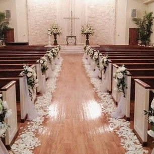 the aisle is decorated with white flowers and petals