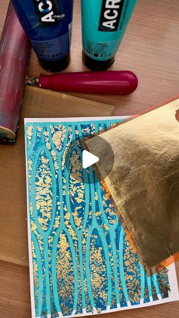 some crafting supplies are laying out on a wooden table, including glue and paper