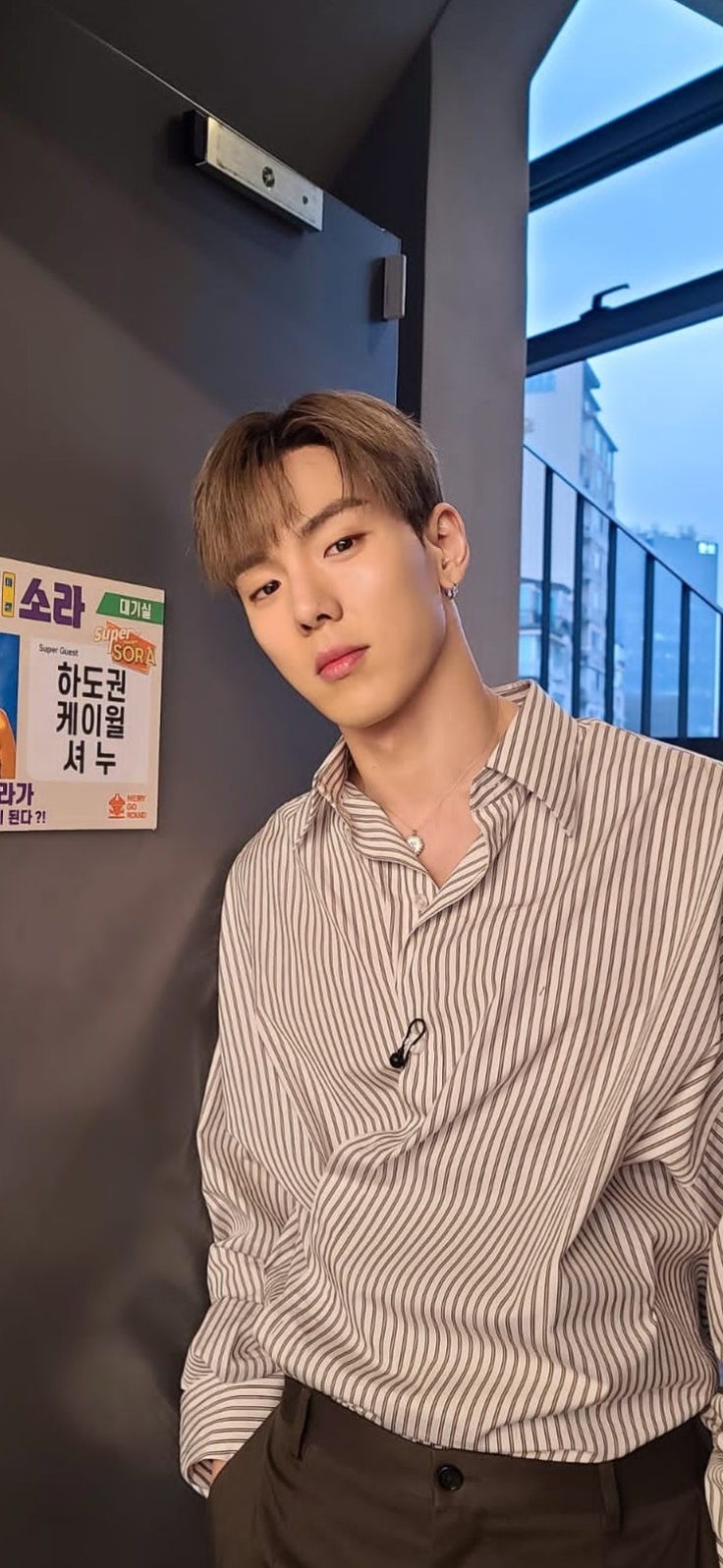 a young man standing in front of a wall