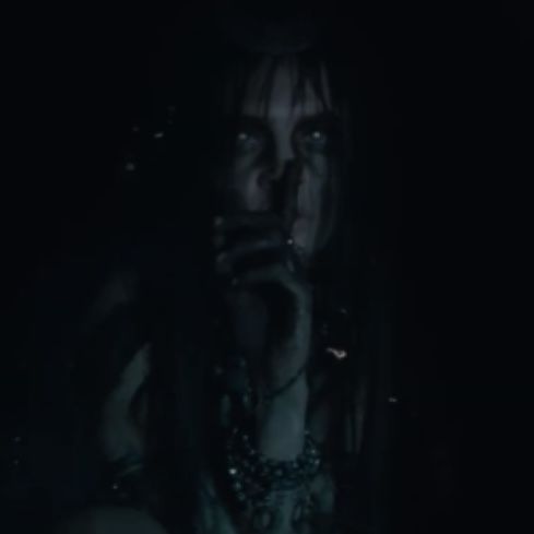 a woman with long hair is in the dark