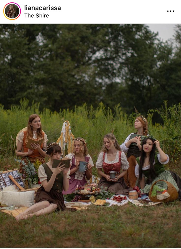 a group of women sitting on top of a grass covered field next to each other