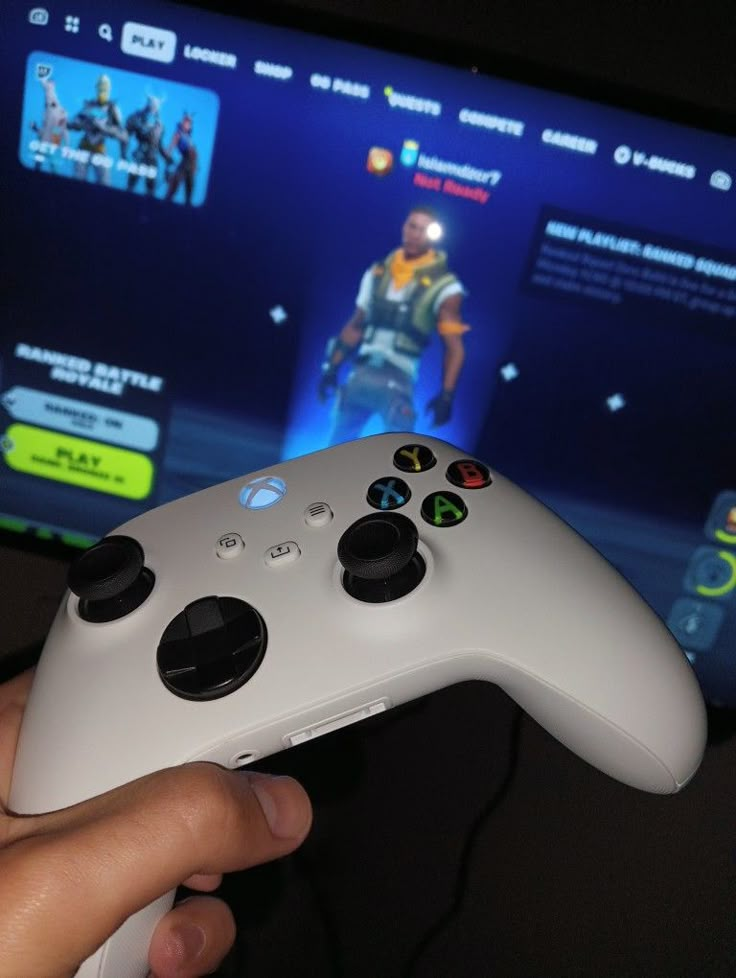 a person holding a video game controller in front of a tv screen with the fortnix logo on it