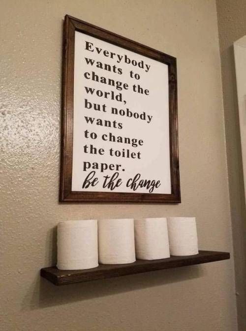 a bathroom with toilet paper rolls on the shelf and a sign above it that says, every body wants to change the world but nobody wants to change