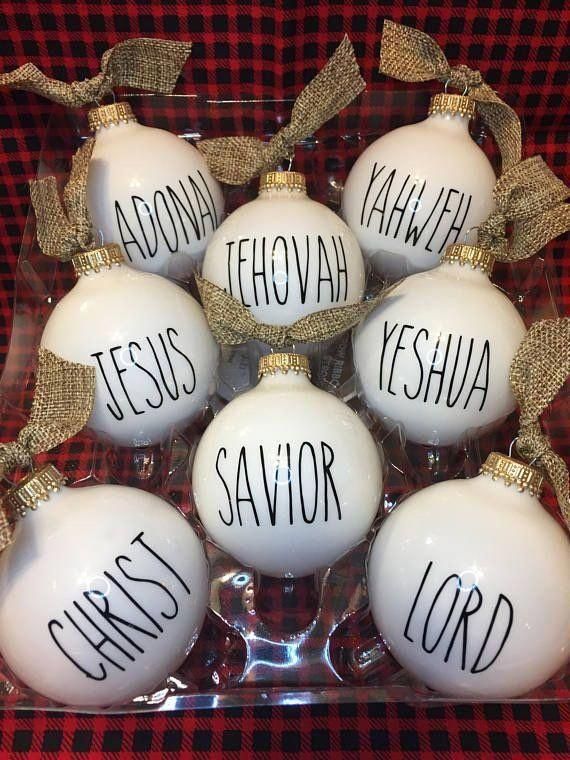 christmas ornaments with names on them are in a glass box and tied to the side