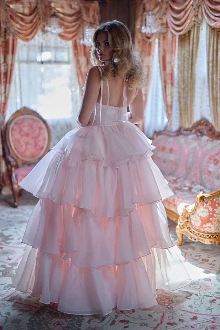 Embrace the wild beauty of the frontier in this enchanting two-piece ensemble. The slinky slip dress, adorned with a flirtatious bow-tied bust, pairs perfectly with a flowing tiered skirt. An extra-long satin ribbon closure adds a touch of frontier elegance. In a desert rose pink as tender as a cowboy's heart, this ensemble blooms with frontier charm. This is a two piece set. Two piece slip dress set with tiered maxi skirt Slip dress features a peek-a-boo cutout and underwire cups with a ribbon Pink Victorian Dress, Ruffle Maxi Skirt, Skirt Swimsuit, Puff Dress, Wild Beauty, Tiered Ruffle Skirt, Tiered Maxi Skirt, Girly Dresses, Knitted Coat