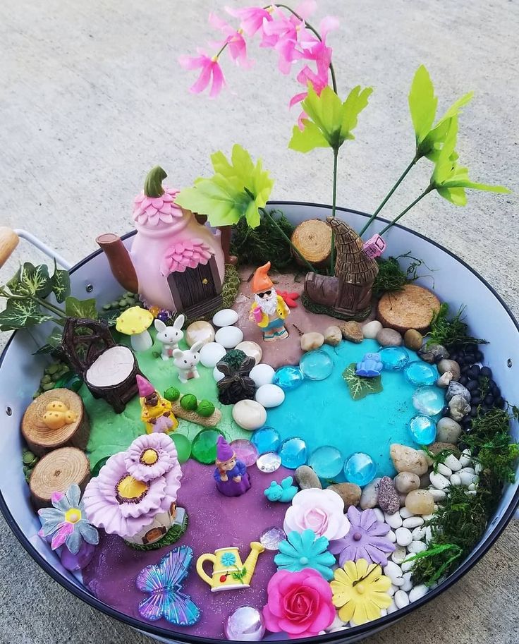 a bowl filled with lots of fake flowers and rocks