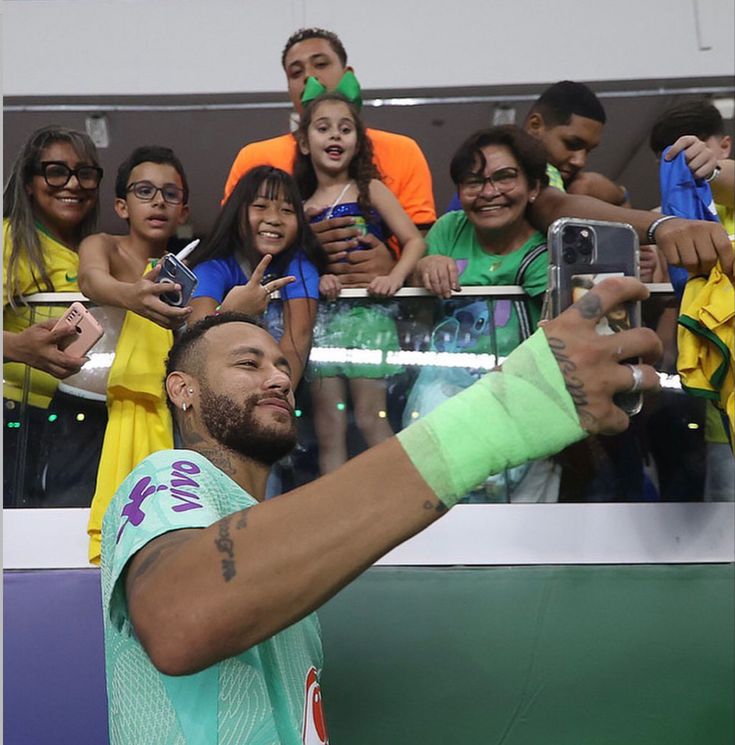 a man taking a selfie with his cell phone in front of a group of people