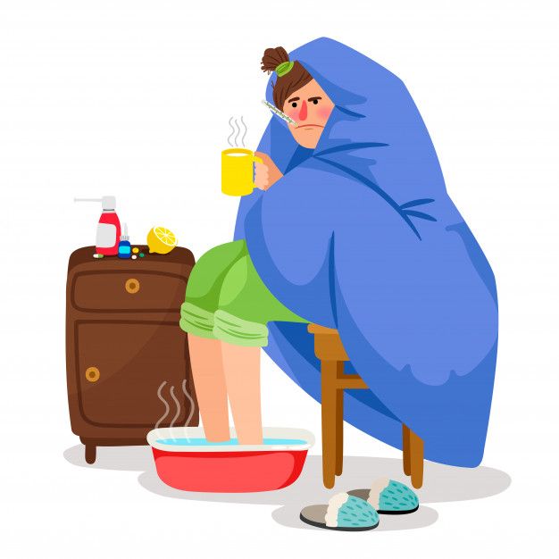 a woman wrapped in a blanket is drinking from a mug while sitting on a chair