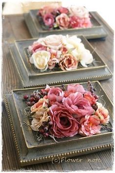 three trays with flowers on them sitting on a table