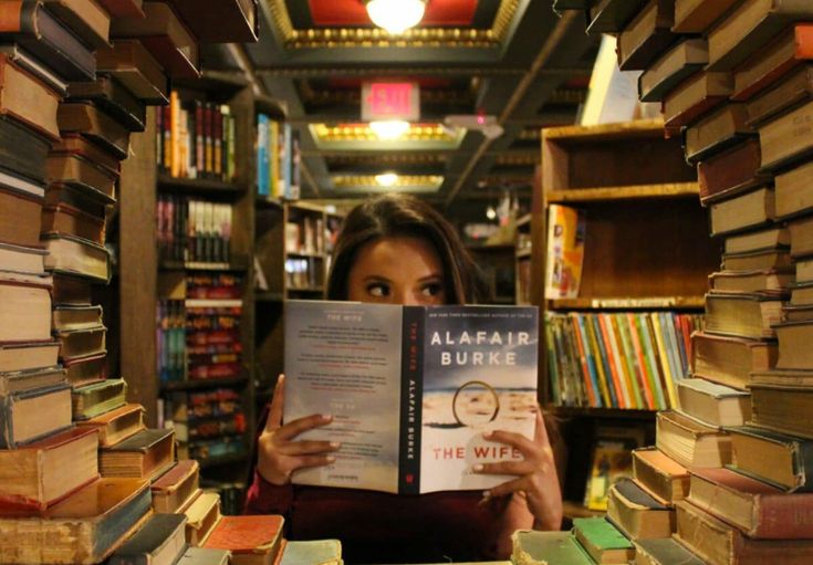 a woman reading a book in a library