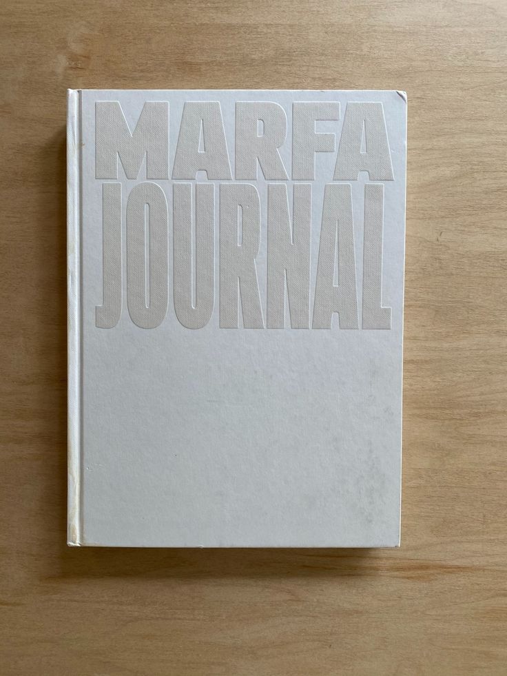 a white book with the words marefa journal written on it sitting on a wooden surface