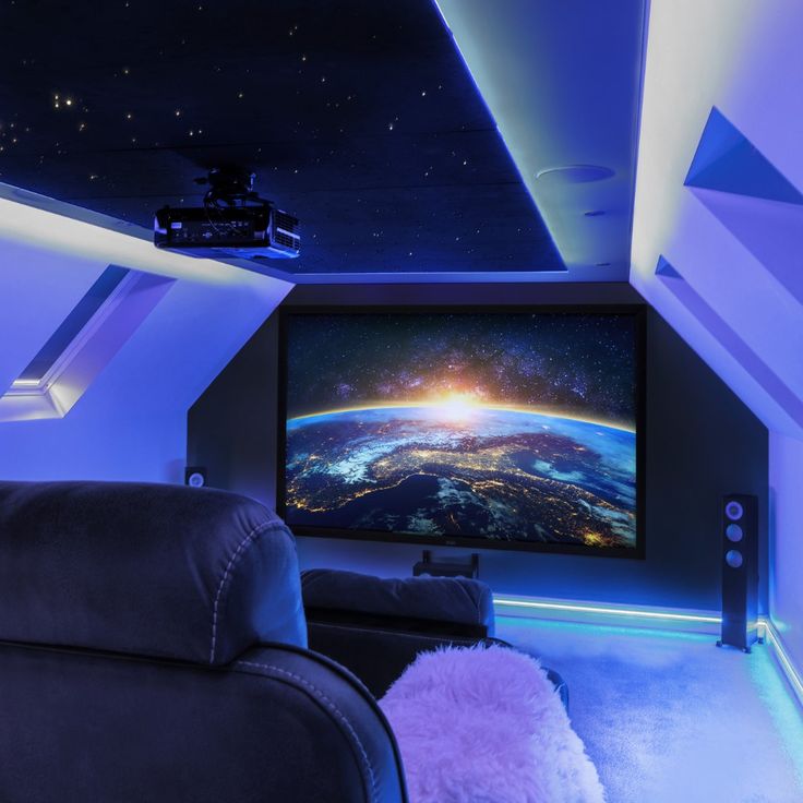 a home theater with a large screen on the wall and purple lights in the ceiling