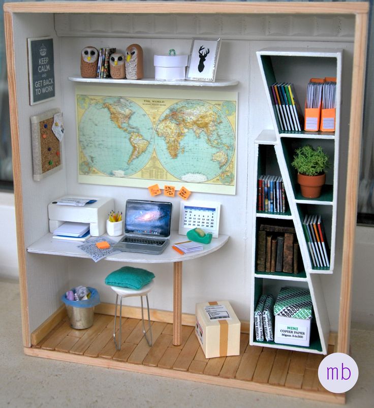 a dollhouse desk with a laptop and bookshelf