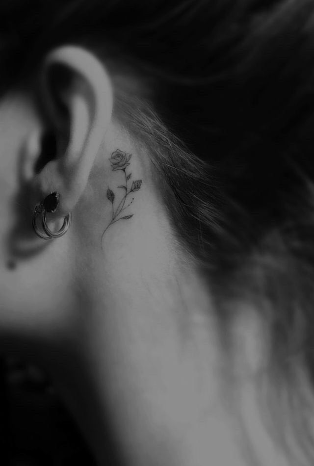 a woman's ear with a flower tattoo on it