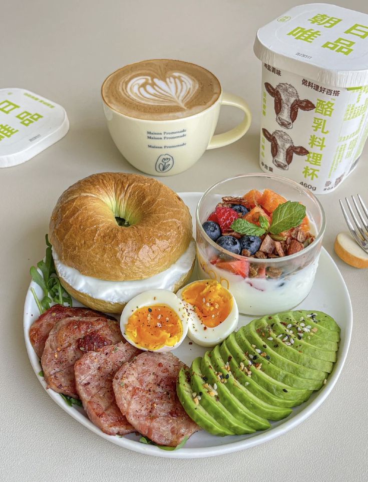 a white plate topped with breakfast foods next to a cup of coffee