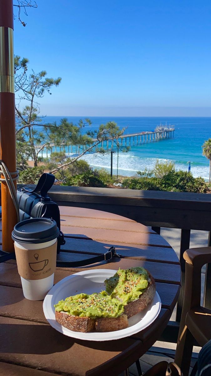 an open faced sandwich on a plate with a cup of coffee sitting next to it