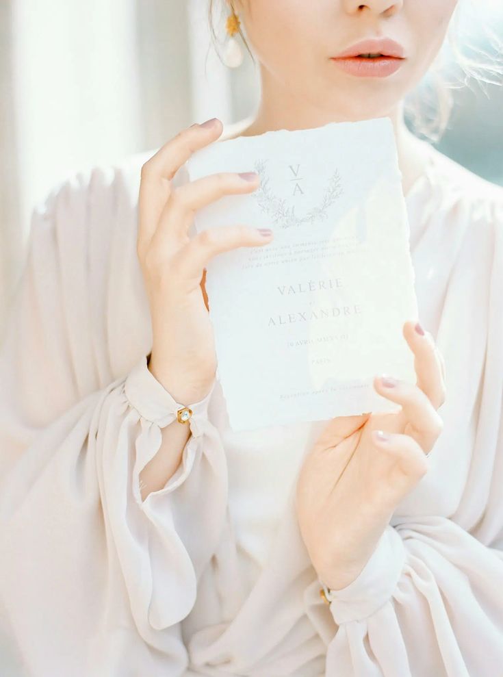 a woman holding up a piece of paper in front of her face