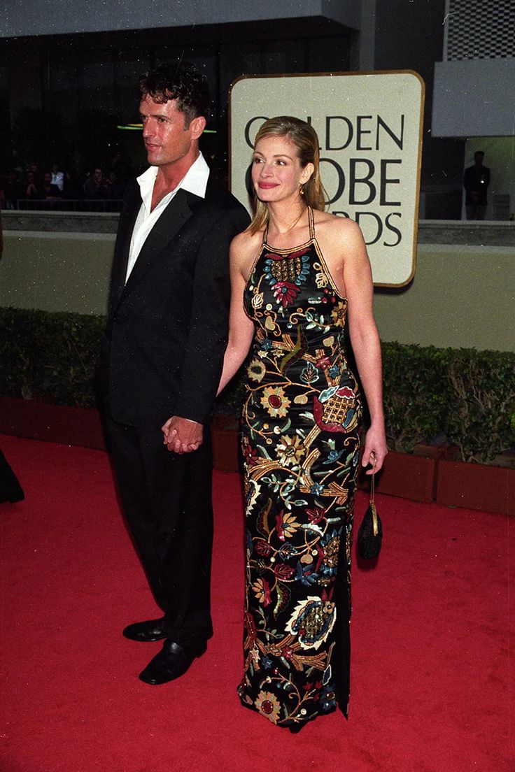 a man and woman walking down a red carpet