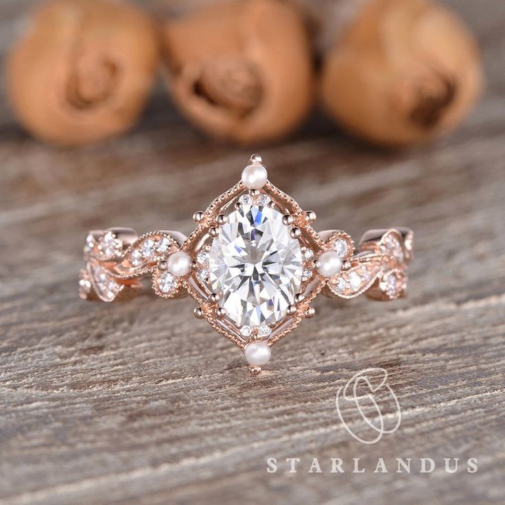 a close up of a diamond ring on a wooden surface with nuts in the background