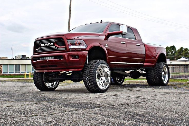 a red ram truck parked on top of a parking lot next to a power pole