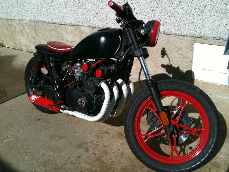 a red and black motorcycle parked next to a building