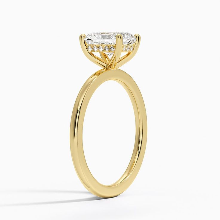 a yellow gold engagement ring with an oval cut diamond in the center and side stones