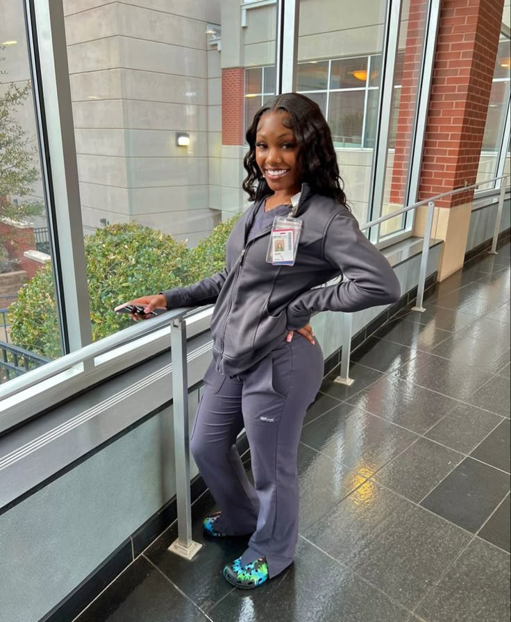 a woman is standing in front of a window with her hands on her hips and smiling at the camera