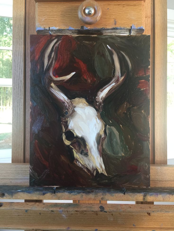 a painting of a deer's skull on a wooden frame