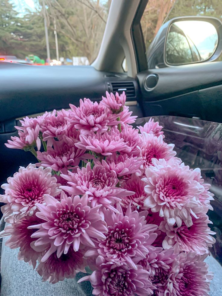 a bunch of pink flowers sitting in the passenger seat of a car