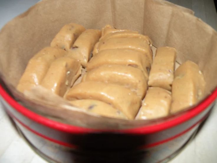 some kind of food that is in a red bowl on the table and brown paper