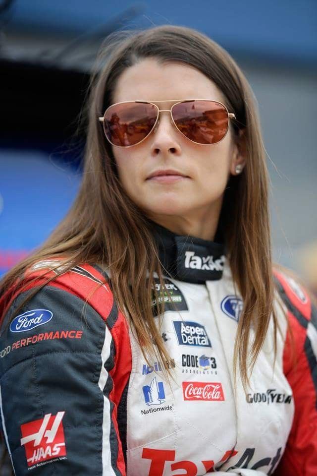 a woman wearing sunglasses standing in front of a building