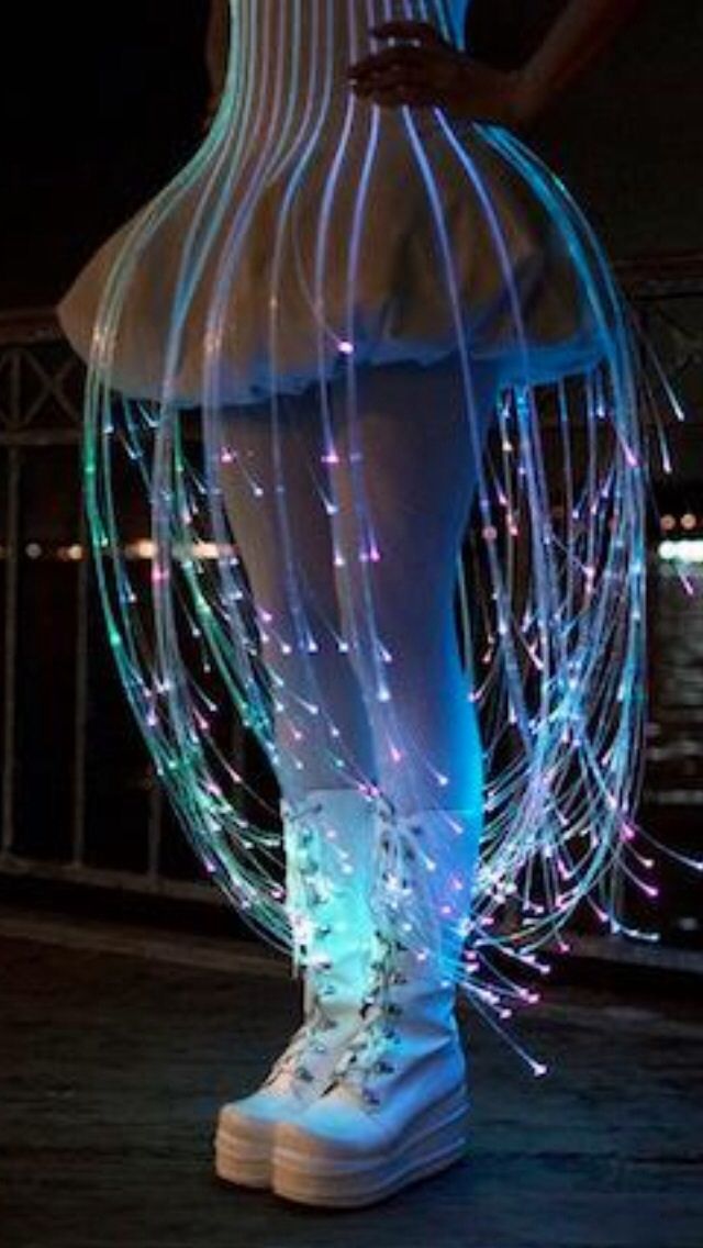 a woman in white boots standing on top of a wooden floor with lights all around her