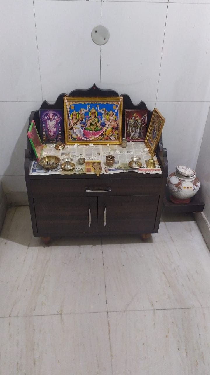 there is a small shrine with pictures on the wall and other items in front of it