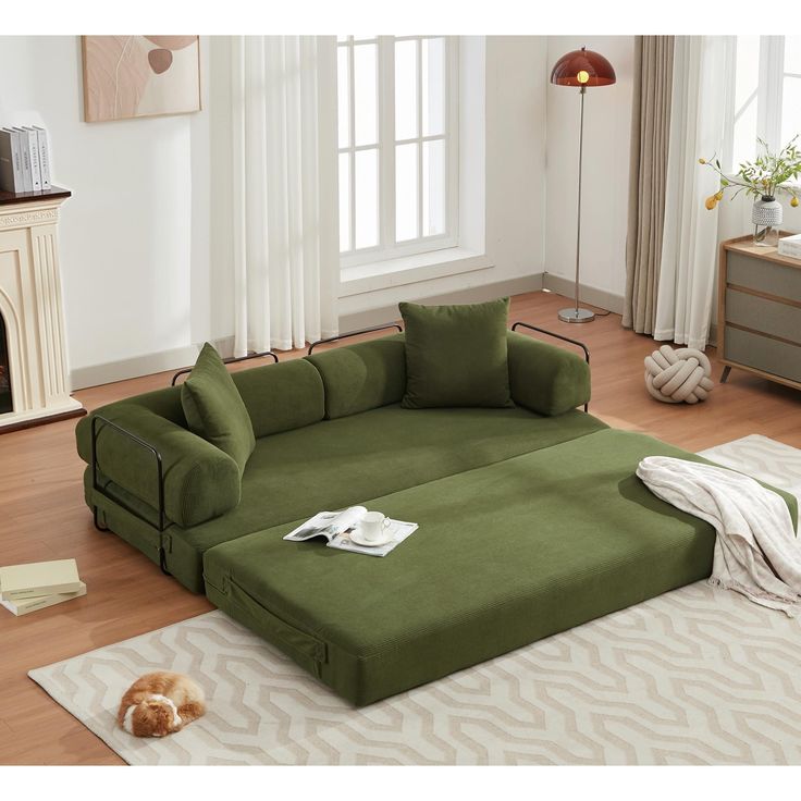 a living room with a large green sectional couch and white rugs on the floor