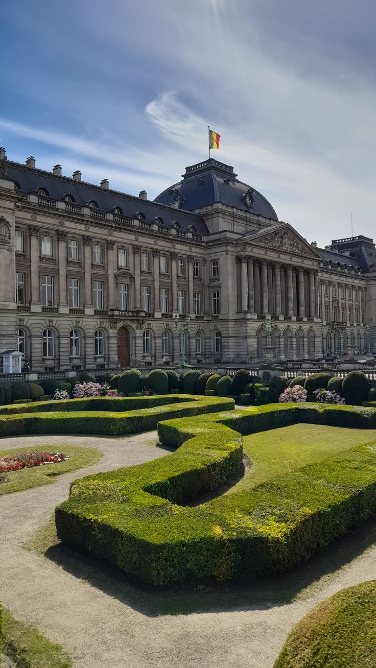 a large building with many hedges in front of it