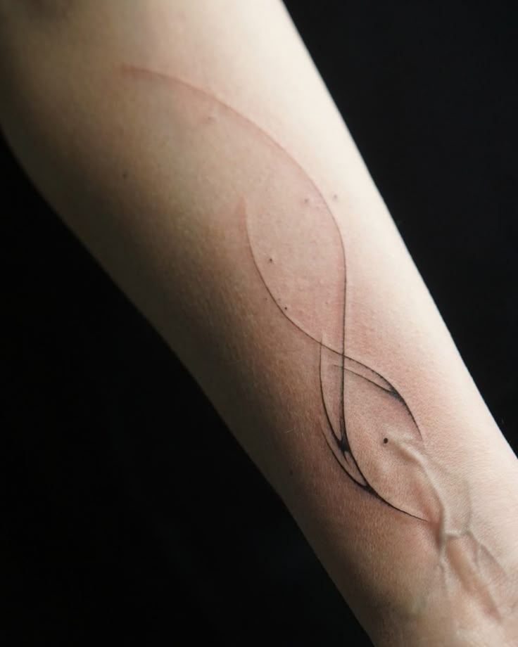 a woman's arm with a wave tattoo on it