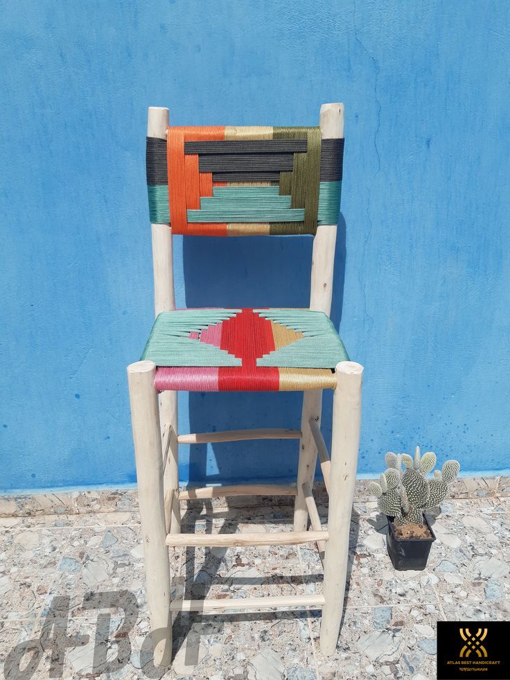 a chair made out of strips of wood and painted with different colors on the seat