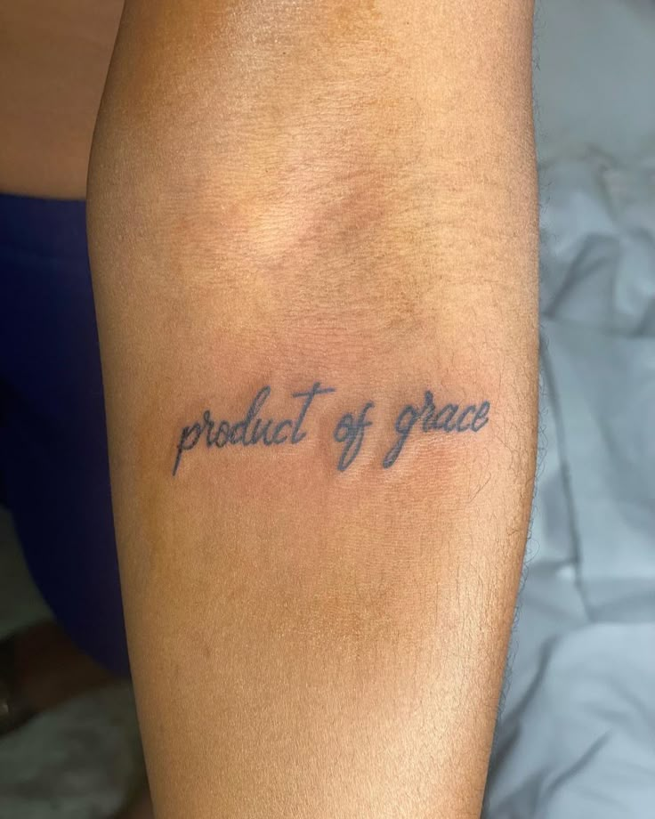 a person with a tattoo that says product of grace