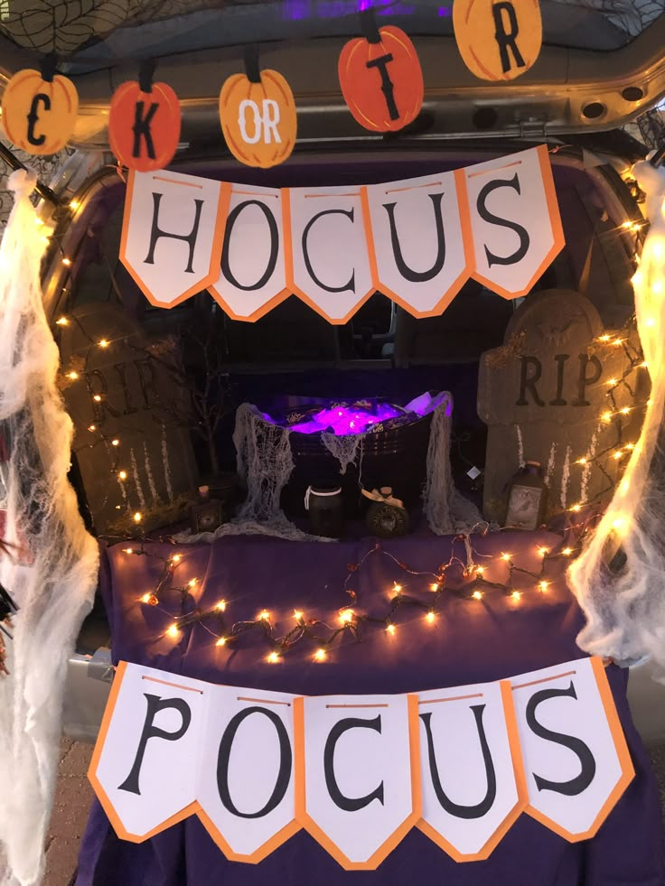 the trunk of a car decorated with halloween decorations and lights for hoccus pocus