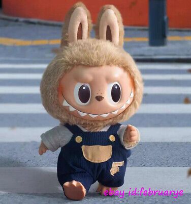 a stuffed animal is dressed in overalls and has big eyes, ears, and nose