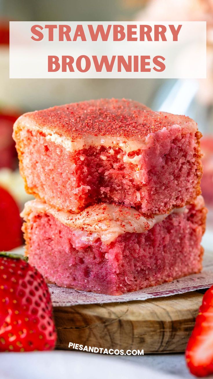 two strawberry brownies stacked on top of each other with strawberries in the background