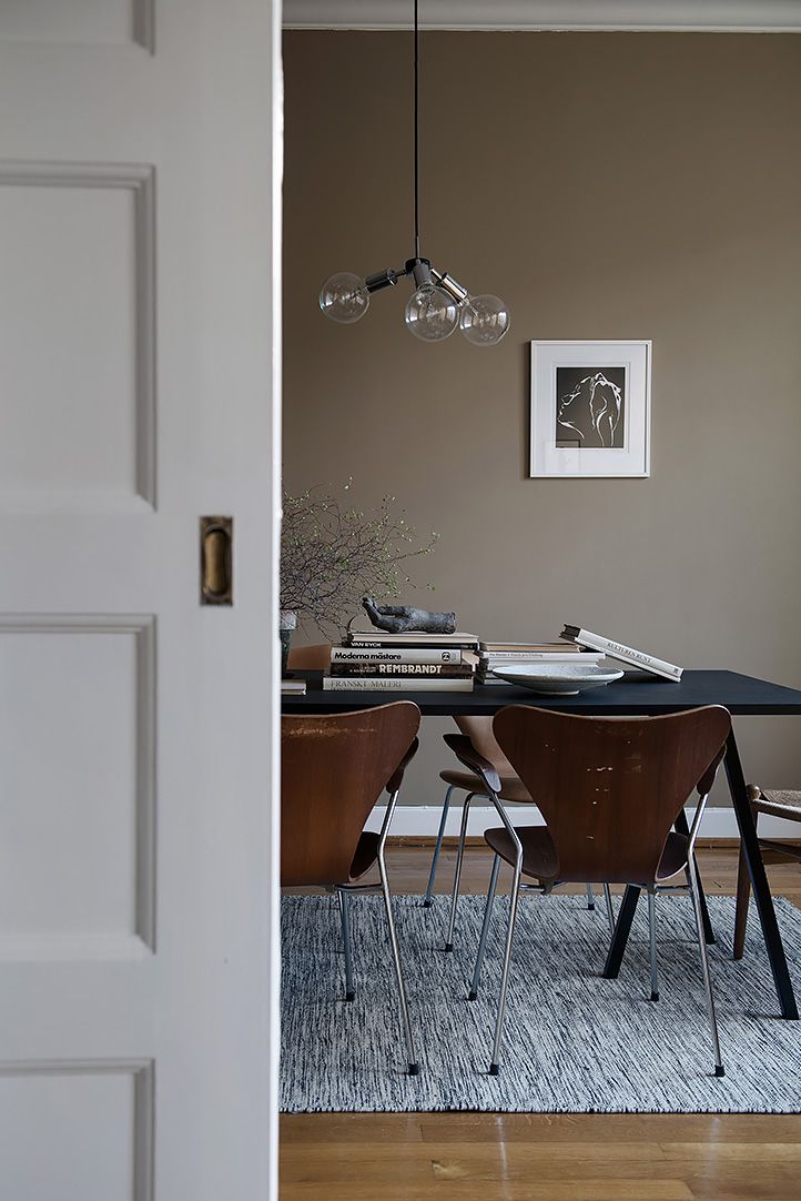 a dining room table with four chairs in front of it and a door leading to another room