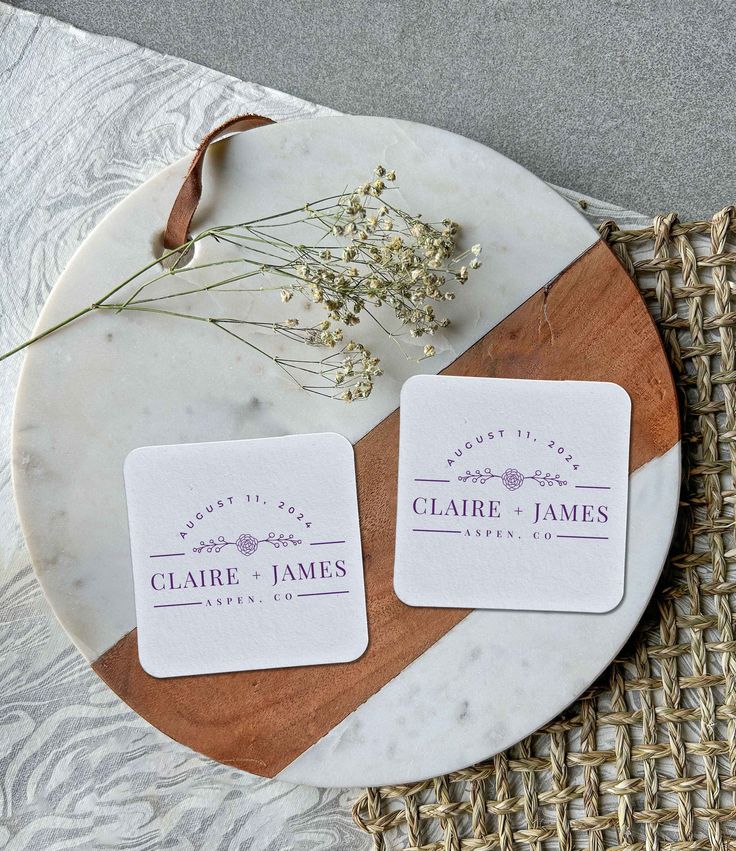 two square business cards sitting on top of a plate