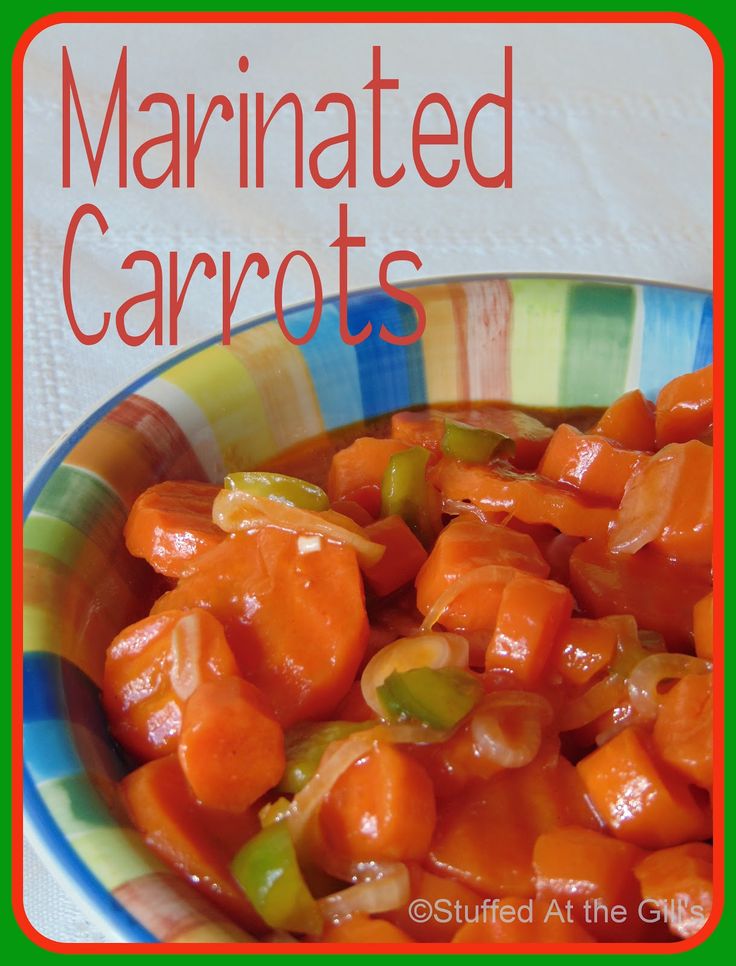 a colorful bowl filled with sliced carrots on top of a white table next to a green and blue striped napkin