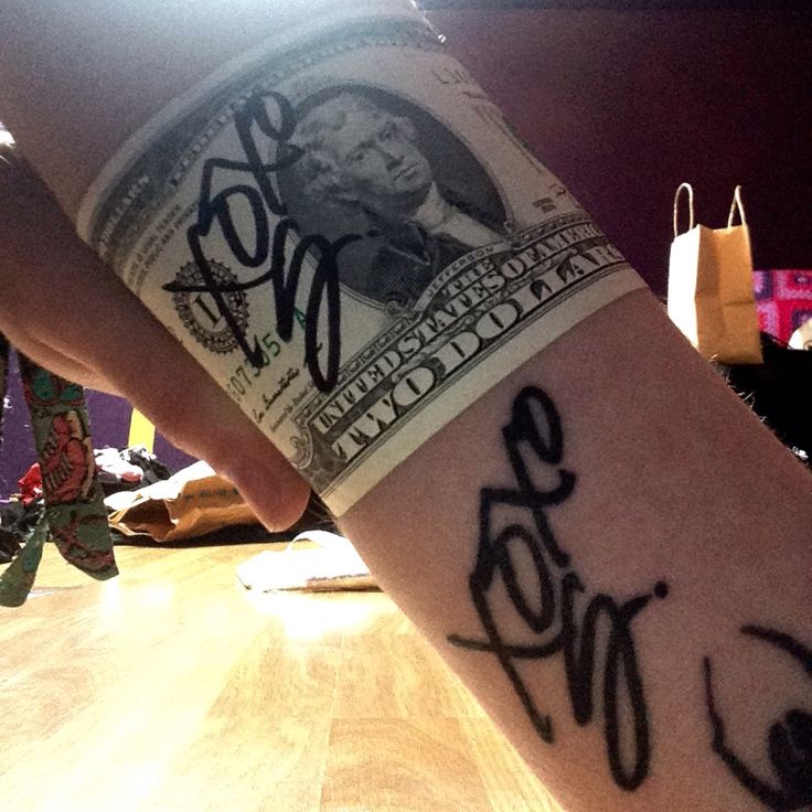 a person's arm with money on it and the word love written in cursive writing