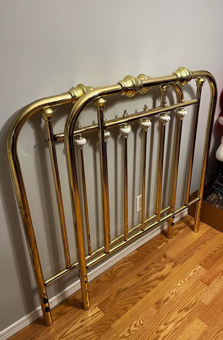 a gold metal radiator on the floor next to a wall