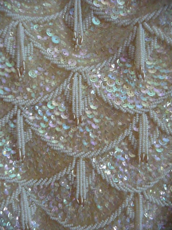 sequins and beads are arranged on the back of a dress that is being displayed