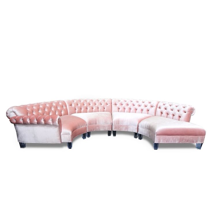 a pink and white sectional couch with black legs