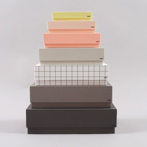 a stack of different colored boxes sitting on top of each other in front of a white background